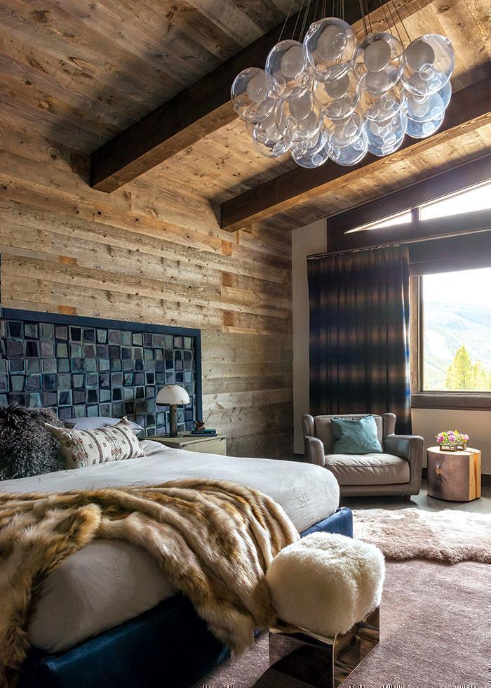 Embroidered Coral & Tusk Berber pillow on a bed in Montana's Yellowstone Club in Mountain Living Magazine