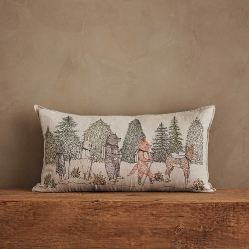 Coral & Tusk 14 × 26-inch embroidered linen Hikers Pillow with a camp theme, featuring a cat, bunny, bear, fox, and deer wearing backpacks and carrying hiking sticks, set against a dense forest backdrop.