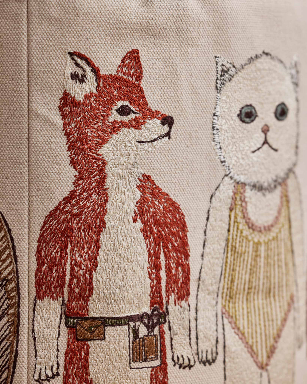 Close-up of Coral & Tusk Pocket Dolls Bucket, a cylindrical canvas storage basket, showing detailed embroidery of Fox and Baby Cat.