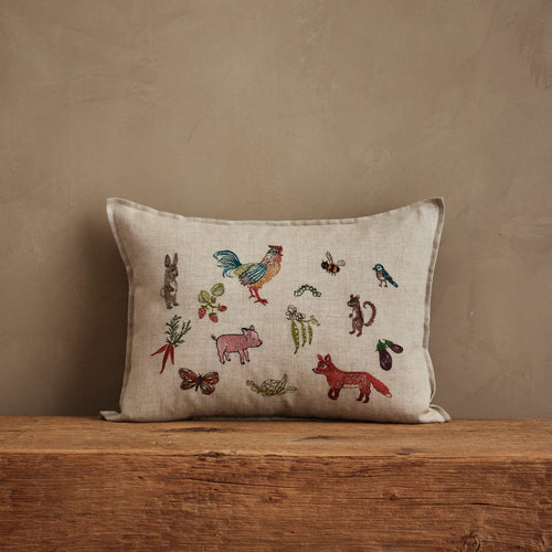 Coral & Tusk 12 × 16-inch embroidered linen Garden Gathering Pillow depicting farm and garden life, featuring a colorful rooster, a sneaky fox, and other embroidered animals among pollinators, fruits, and vegetables.